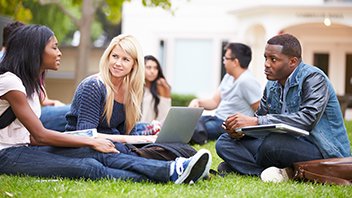 Group of students with an open laptop having a discussion