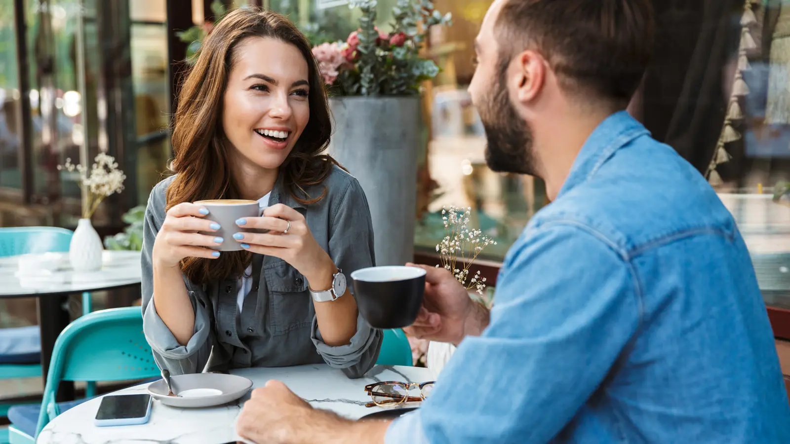 man and woman having a conversation over coffee at a cafe