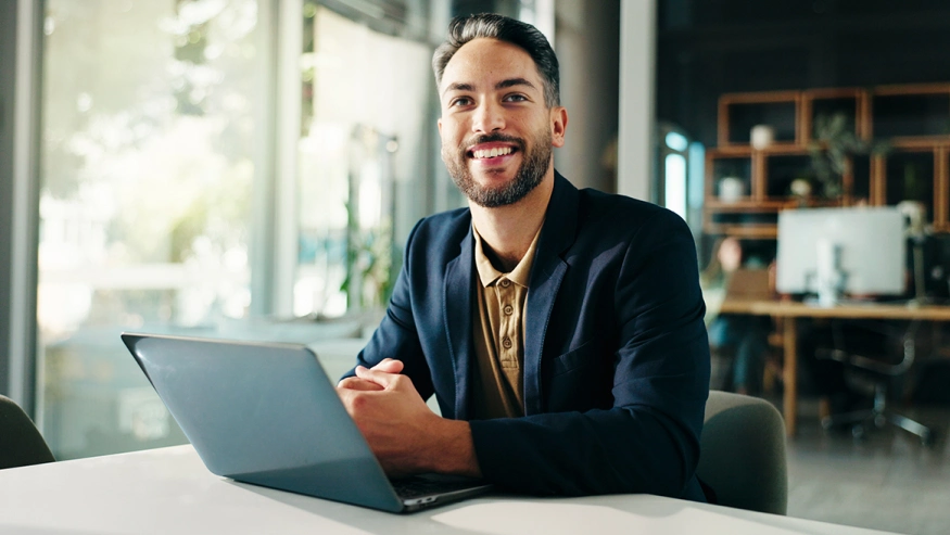 Young man seated using a laptop to research investments